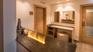 A modern bathroom with a wooden vanity, a mirror, and a sign indicating the WC. - Hotel Alpenfeuer Montafon (Sankt Gallenkirch)
