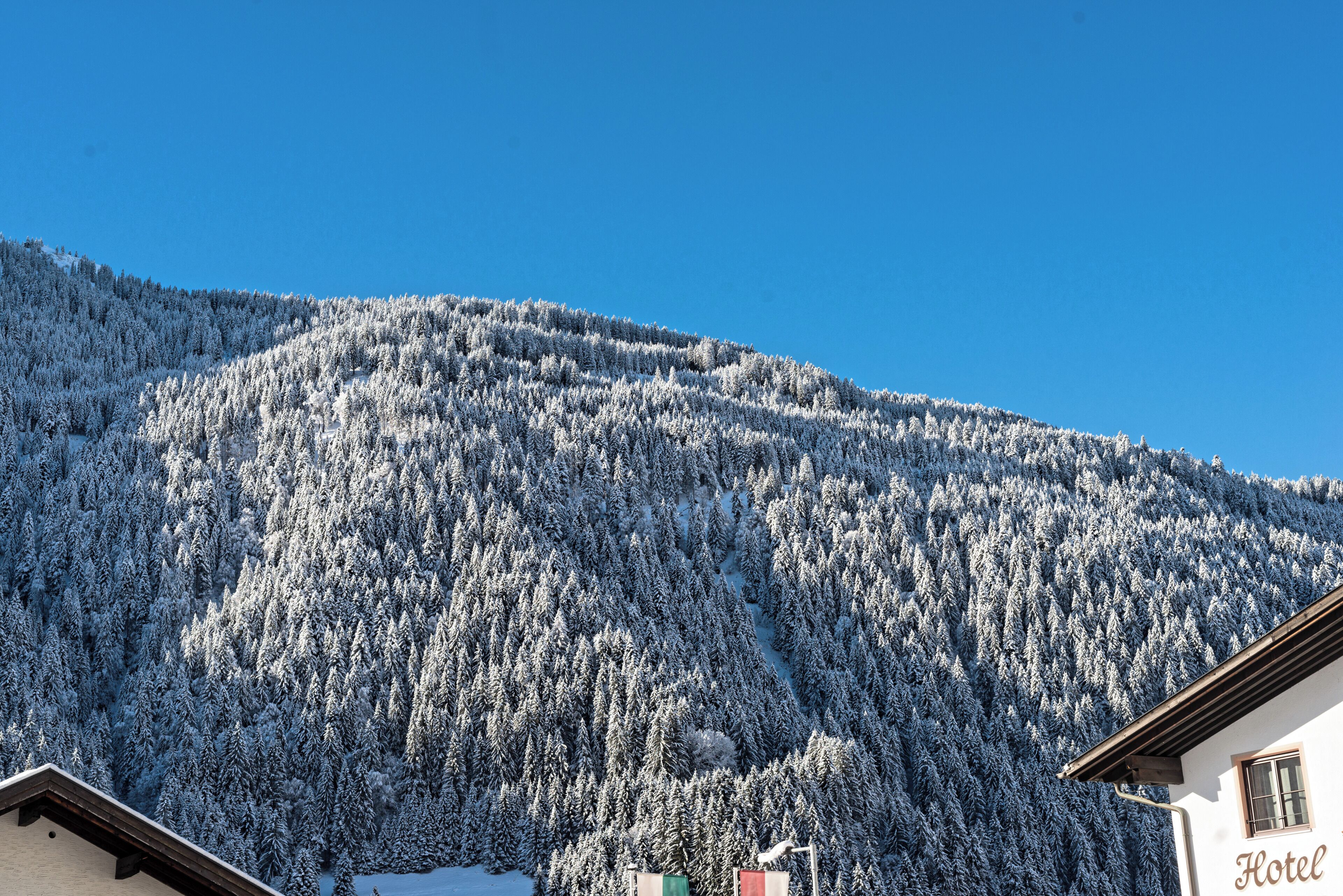 A building with a sign that reads 'Hotel' against a backdrop of a snow-covered mountain.
