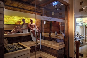 A sauna with wooden benches and a glass enclosure, labeled 'FINN-SAUNA 85°'. - Hotel Alpenfeuer Montafon (Sankt Gallenkirch)