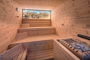 A wooden sauna with benches and a sauna table. - Hotel Alpenfeuer Montafon (Sankt Gallenkirch)