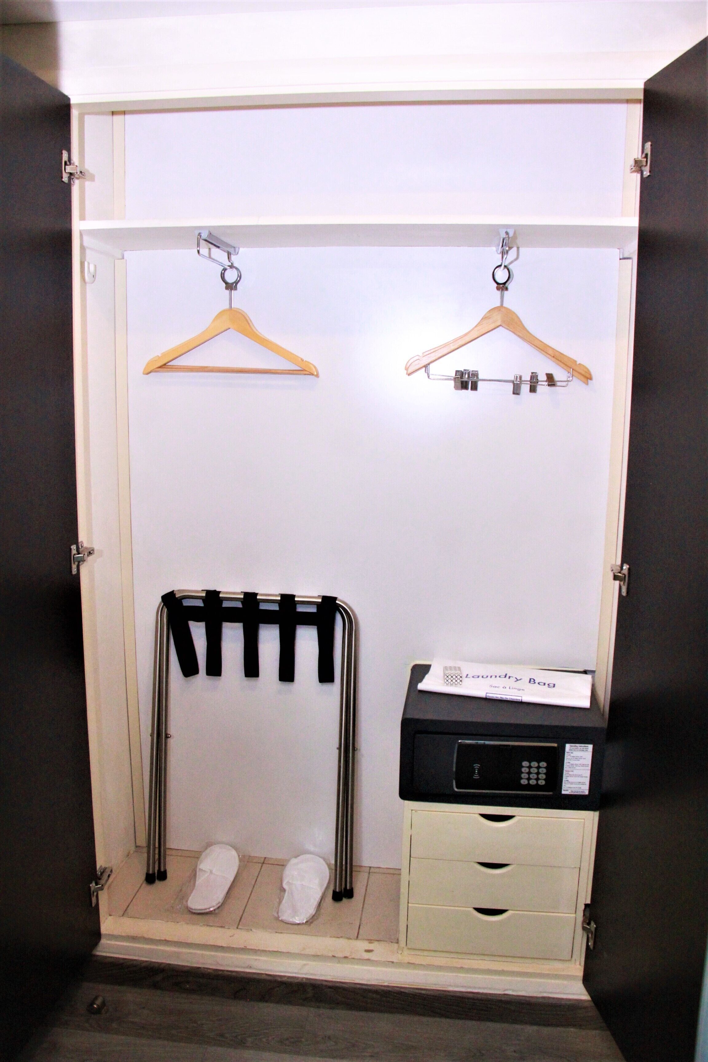 A walk-in closet with a shoe rack, a hanging organizer, and a laundry bag on a counter.