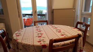 Un tavolo da pranzo rotondo con tovaglia a motivi floreali, circondato da sedie in legno.