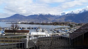 Una marina con barche, vista su un lago e montagne sullo sfondo.