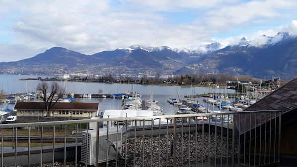 A marina with boats, a view of a lake, and mountains in the background.