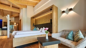 Un dormitorio moderno con una cama de madera, un sofá y una mesita.