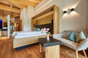 Un dormitorio moderno con una cama de madera, un sofá y una mesita.