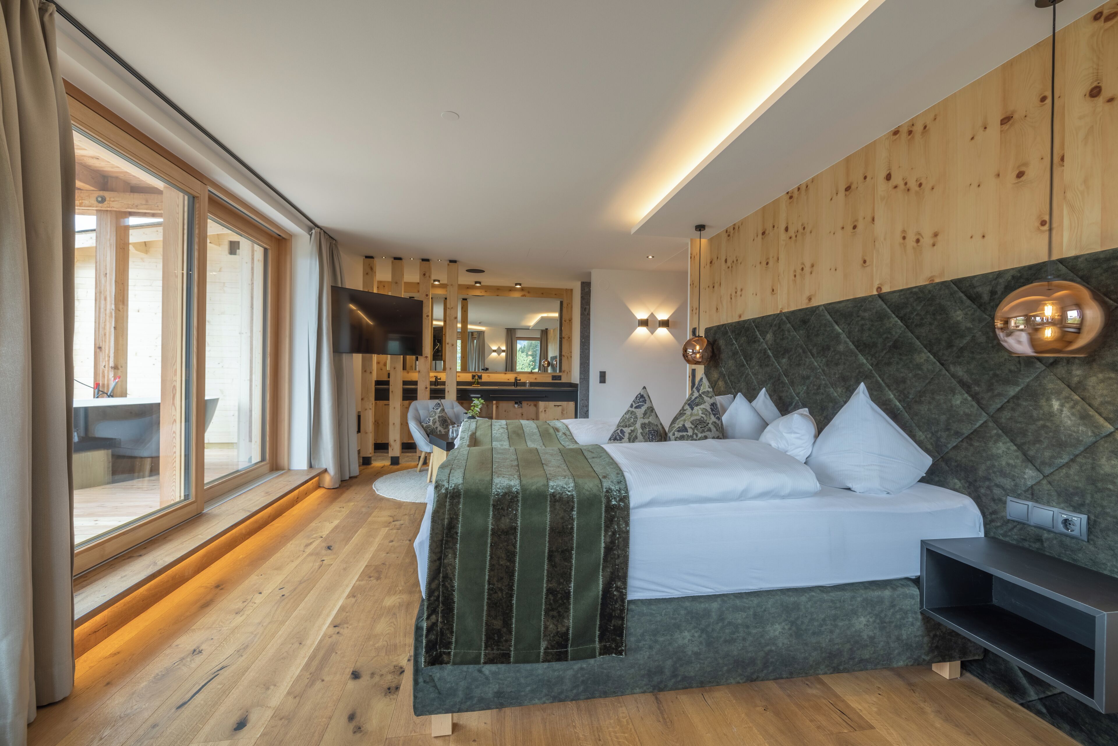 Une chambre à coucher moderne avec un grand lit, une tête de lit en bois et un téléviseur.