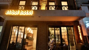 The exterior of the Elbol Hotel with a scooter parked in front.