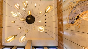 A ceiling with multiple hanging light fixtures and a mural on the wall.