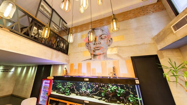 A modern interior with a large aquarium, a mezzanine level, and a mural on the wall.