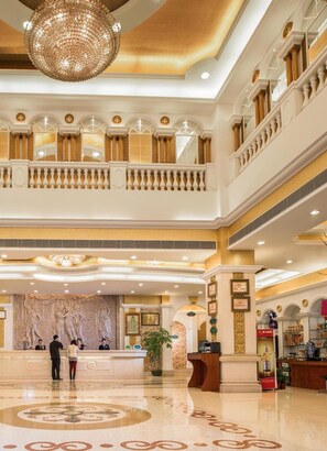 A grand lobby with a marble reception desk, a chandelier, and a balcony with ornate railings. - Shenzhen Vienna Hotel Yousong Branch (Shenzhen)