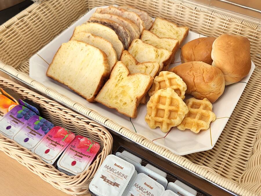 Un buffet de petit-déjeuner proposant un assortiment de pains, de gaufres et de confitures.