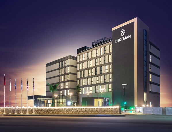A modern hotel with multiple floors, a prominent logo, and a well-lit entrance. - Dedeman Cizre (Cizre)
