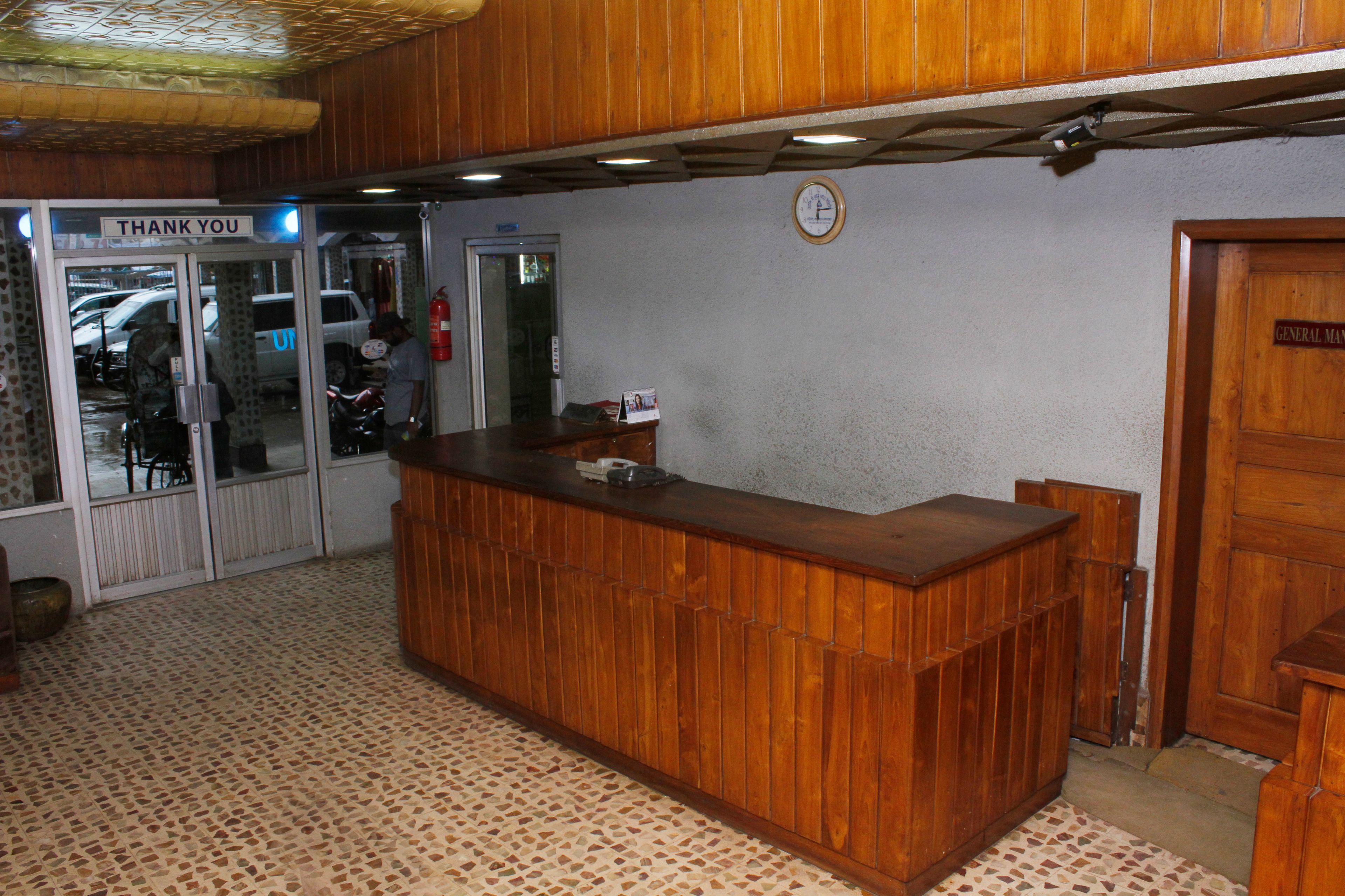 A reception desk with a clock on the wall, a "Thank You" sign above the entrance, and a "General Manager" sign on the door.