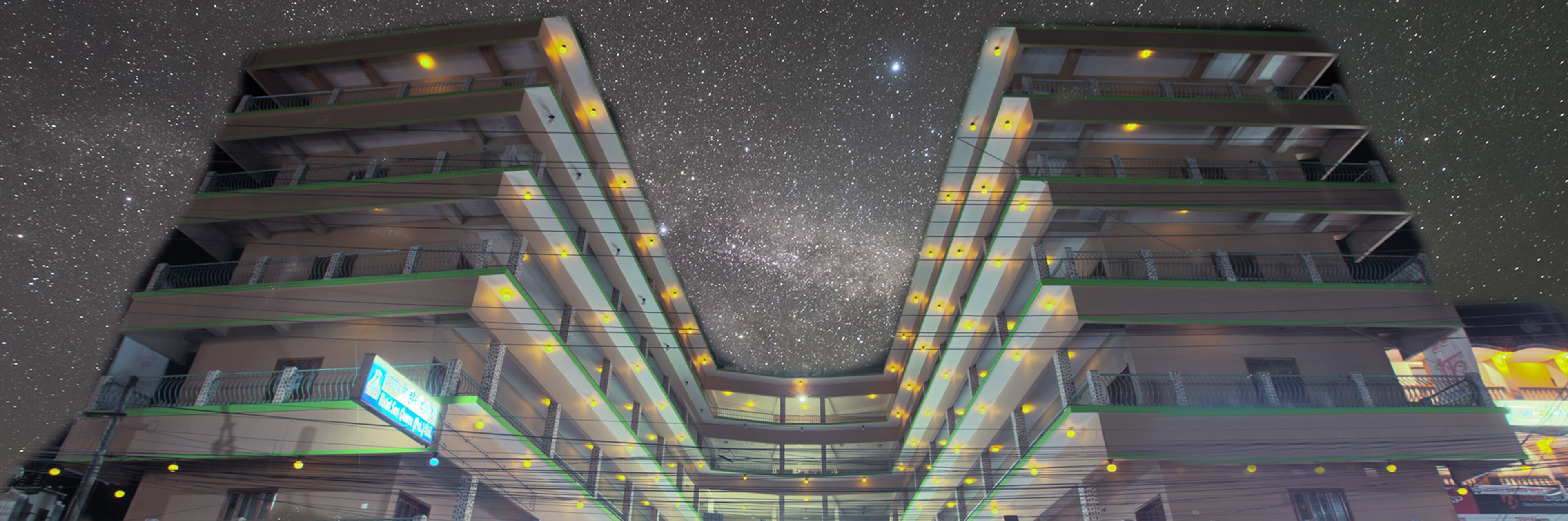A multi-story hotel with a central atrium, balconies, and a visible sign with text.