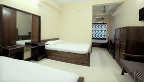 A hotel room with a bed, a desk, a wardrobe, and a television.
