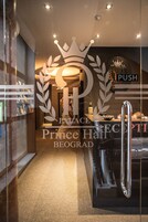 A reception area with a glass door, a crown logo, and a 'PUSH' sign.