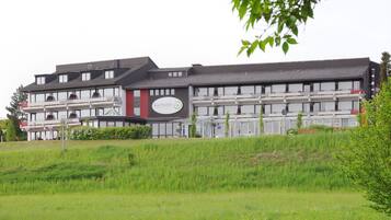 A modern kurhotel building with multiple balconies and a sign.