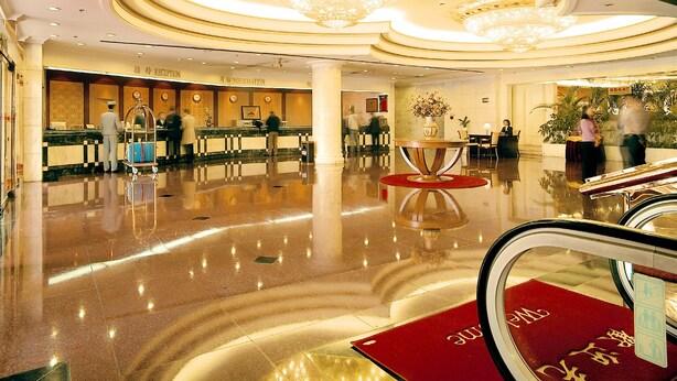 A hotel lobby with a reception desk, information counter, and a chandelier. - ZhongYin Jasper Hotel Baoding (Baoding)