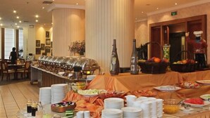 A buffet setup with multiple food stations, including a fruit basket and various dishes. - ZhongYin Jasper Hotel Baoding (Baoding)