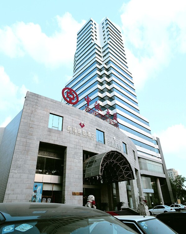 A modern building with a prominent entrance and a large sign above it.