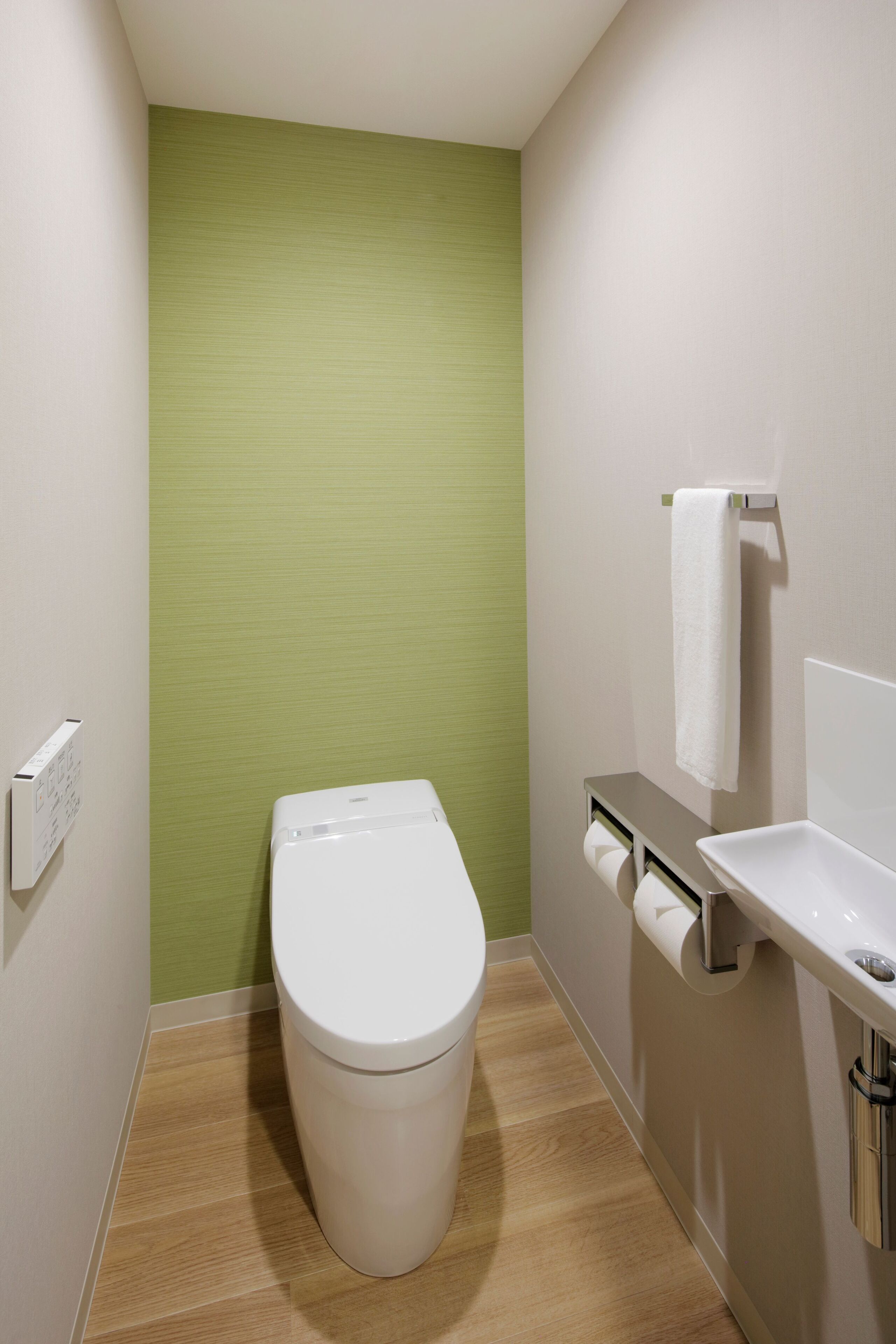 A small bathroom with a toilet, a sink, and a towel rack.