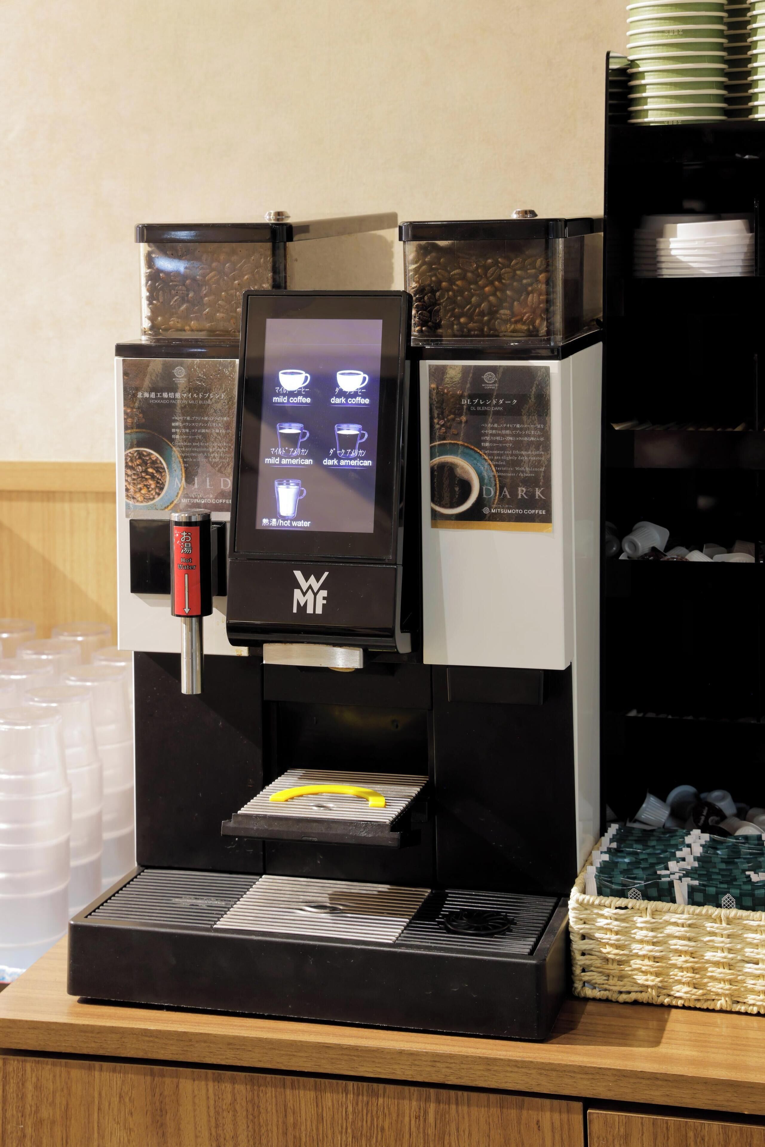 A coffee machine with a digital display, coffee beans, and a water dispenser.