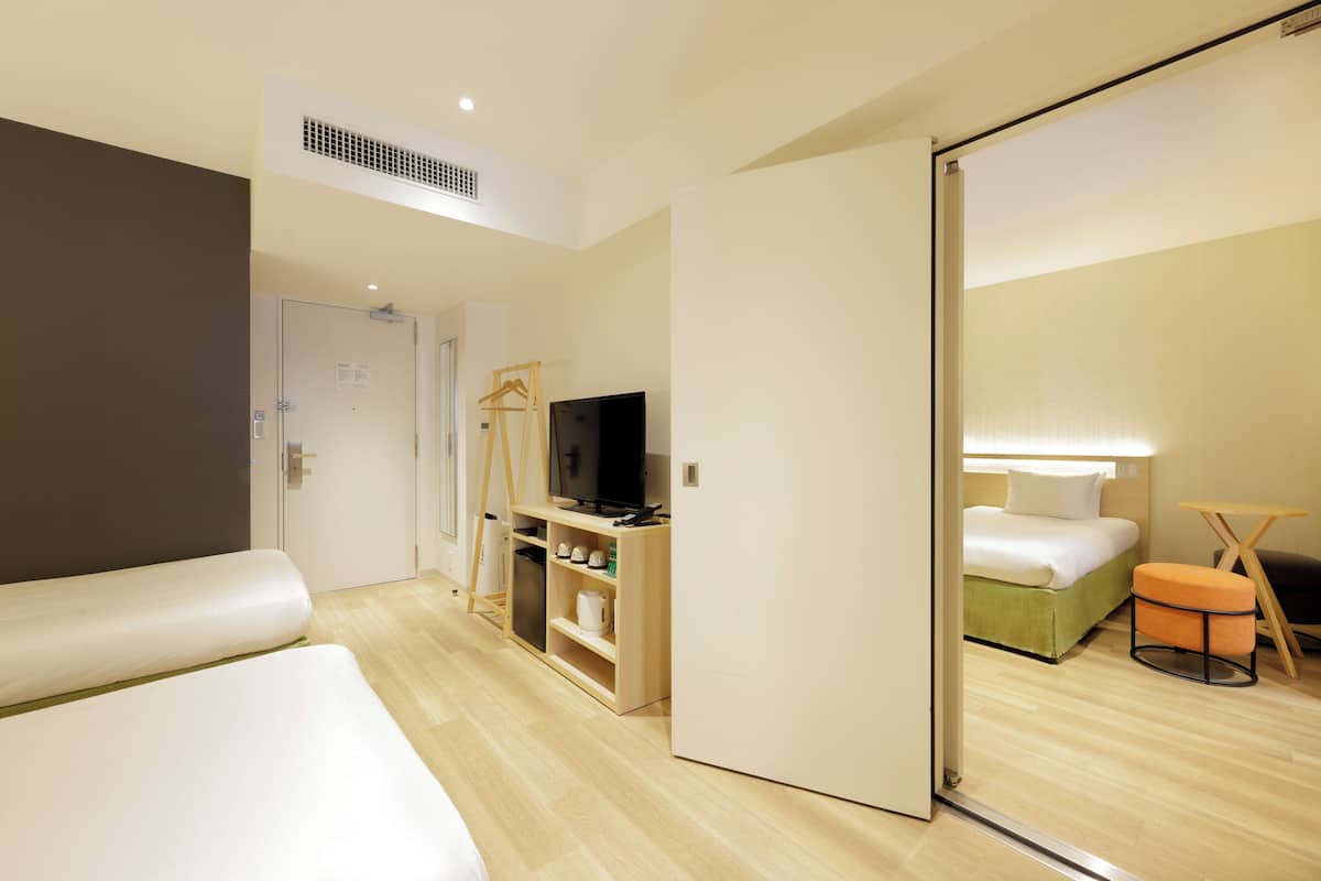 A hotel room with a bed, a TV, a desk, and a mirror.