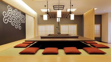 Una habitación moderna con una mesa central, asientos y un detalle decorativo en la pared.