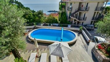 En säsongsöppen utomhuspool och parasoller