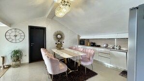 Una cocina moderna con comedor, que incluye una araña, un reloj y un espejo.