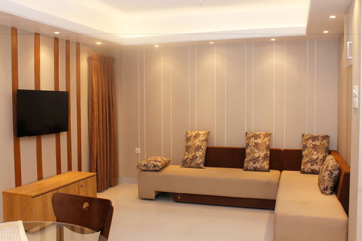 Una sala de estar moderna con un sofá, un televisor y un mueble de madera.