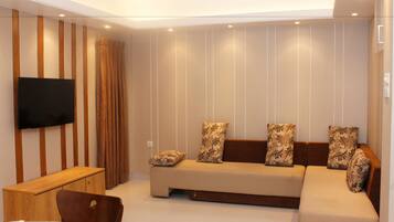 Una sala de estar moderna con un sofá, un televisor y un mueble de madera.