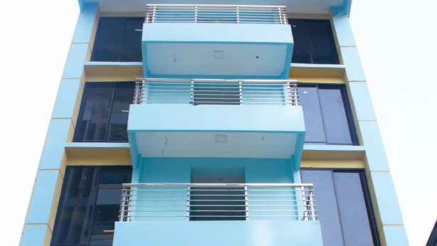 Un immeuble à plusieurs étages, doté de balcons et d’une enseigne indiquant qu’il s’agit d’un immeuble d’habitation.