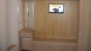 A room with a wooden wardrobe, a small cabinet, and a mirror. - Gunisigi Otel (Bodrum)