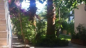 A covered outdoor area with a staircase, potted plants, and a concrete floor. - Gunisigi Otel (Bodrum)
