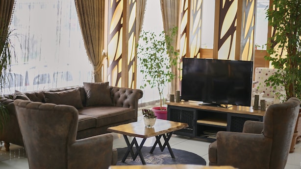 A living room with a sofa, armchairs, a coffee table, and a TV. - Zengin City Hotel (Istanbul)