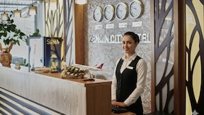 A hotel reception desk with a clock, a sign reading "ZENGIN CITY HOTEL," and a model airplane. - Zengin City Hotel (Istanbul)