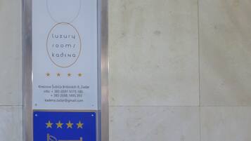 A sign with the name 'luxury rooms kadena' and contact information.