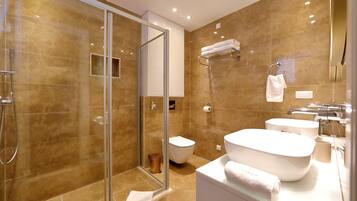 Une salle de bain moderne avec une douche à l’italienne, un lavabo blanc et une grande baignoire.