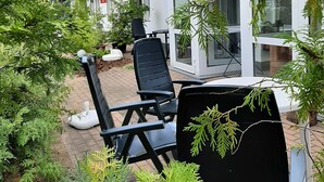 A modern house with a garden patio, featuring two black chairs and a table. - Pension Mark (Hoyerswerda)