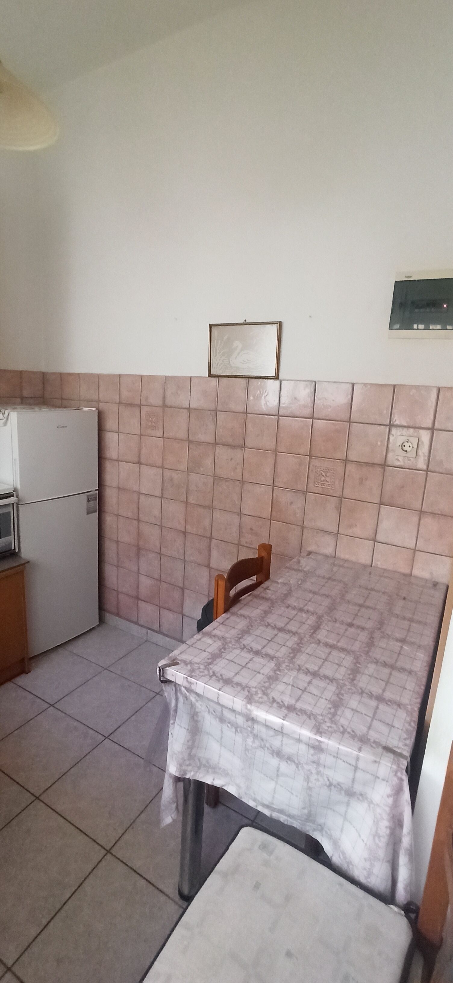 Una cocina pequeña con refrigerador, microondas y salpicadero de azulejos.