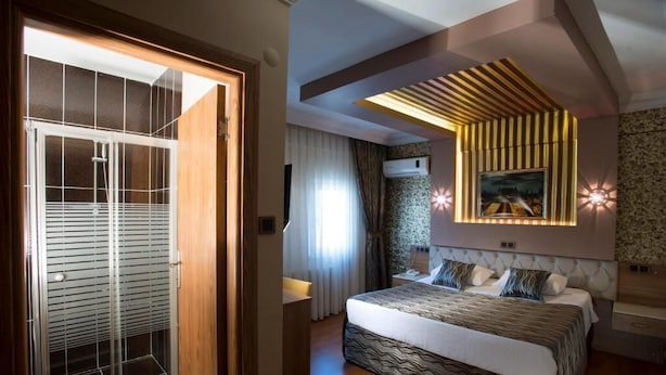 Una camera da letto moderna con un letto grande, un armadio a muro e un soffitto con un lampadario originale.