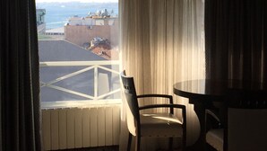 Una stanza con vista sulla città, un tavolo e una sedia.