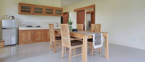 A modern kitchen with wooden cabinets, a dining table, and chairs.