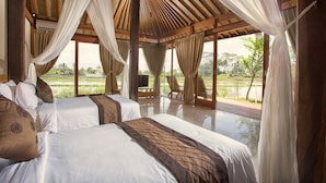 Un dormitorio amplio con dos camas, ventanas grandes y vistas al exterior.