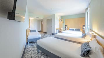 Habitación de hotel con dos camas, un escritorio y un espejo.