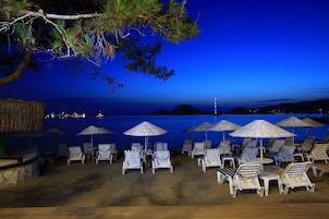 Playa privada, sillas reclinables de playa, sombrillas