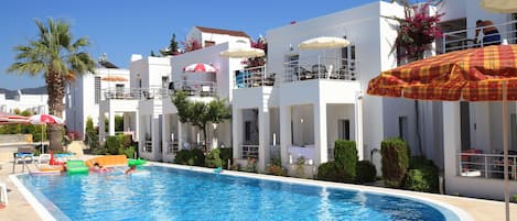 Una piscina al aire libre, sillones reclinables de piscina