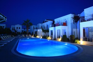 Una piscina al aire libre, sillones reclinables de piscina